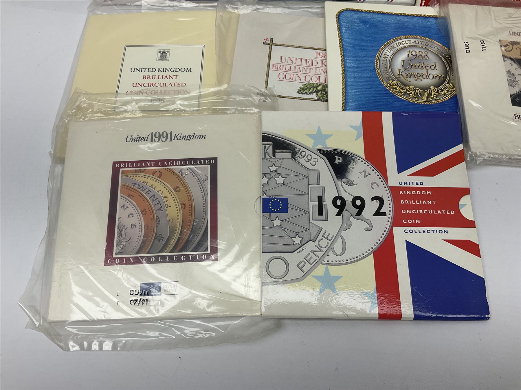Fourteen Queen Elizabeth II United Kingdom uncirculated coin collections, dated 1983, 1984, two 1985, 1986, 1987, 1988, 1989, 1990, 1991, 1992 including dual dated 1992/1993 EEC fifty pence, 1994 and two 1995, all in card folders