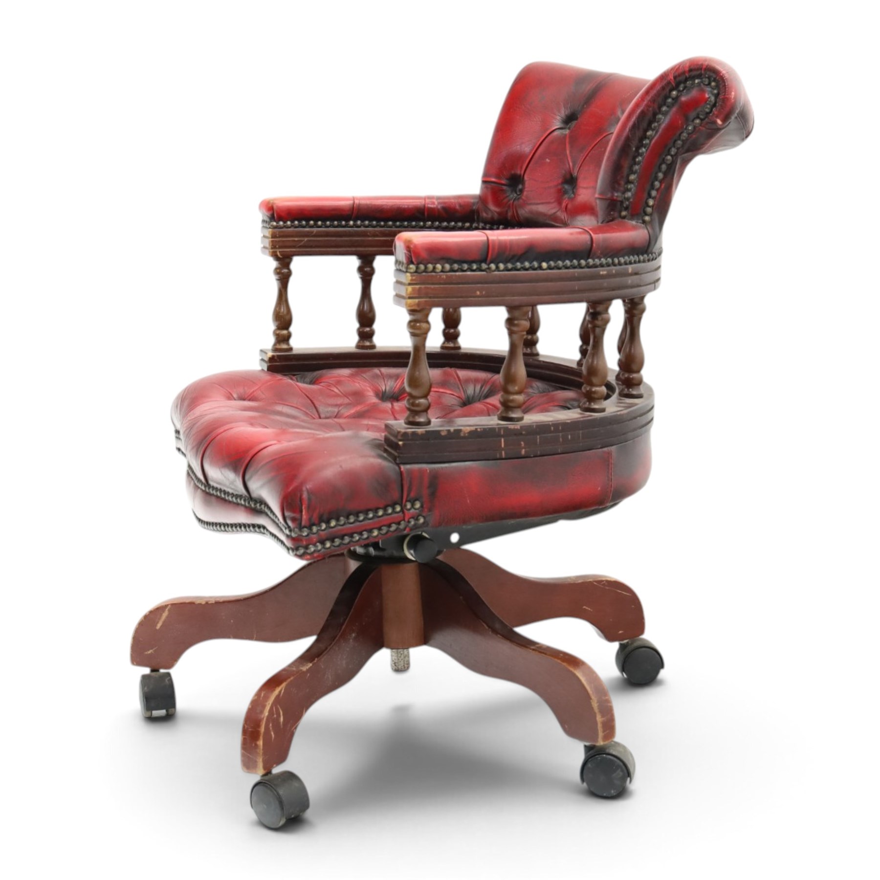 Georgian design captains swivel desk chair, rolled cresting rail over open spindle back on swivel action, upholstered in buttoned oxblood leather