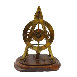 Early 20th century electric skeleton clock, the pyramid shaped brass frame with circular Roman dial and central inner day & date dials, hipp-toggle escapement, with twin train movement, on oval wooden base, H38cm, W31cm    