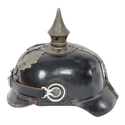 WWI Prussian M1915 Pickelhaube, the black leather skull with removable steel spike finial, steel eagle helmet plate and leather chin strap, one side with a black cockade, the other black and red