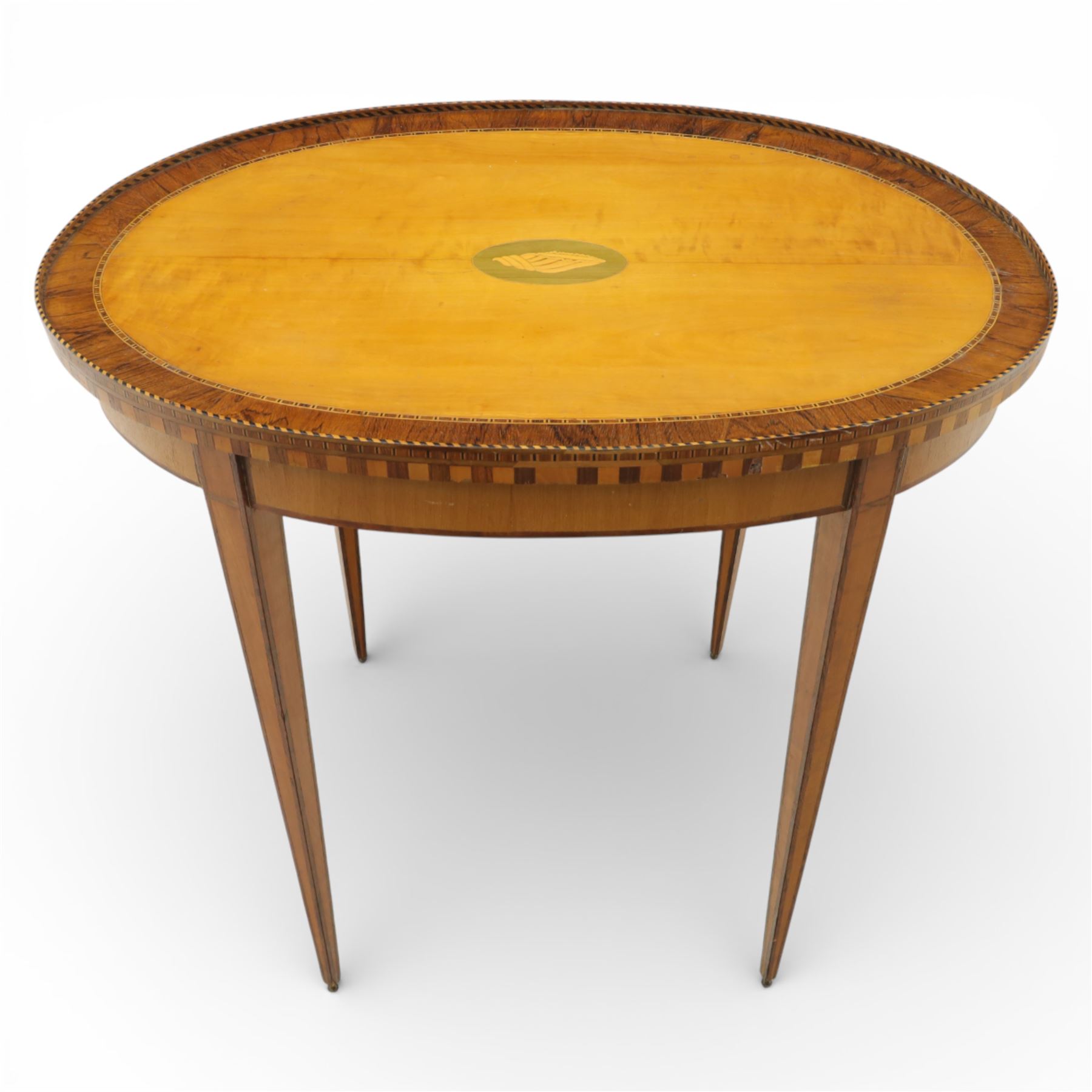 Early 19th century Sheraton revival satinwood oval table, shell motif to the centre bordered by walnut veneer, with inlaid banding, supported on square tapering legs terminating in brass feet