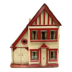 1960s scratch-built wooden doll's house as a red and white painted two-storey house with half-timbered gable and integral garage with opening doors, the hinged front elevation opening to reveal two rooms with glazed windows W47cm H58cm D28cm