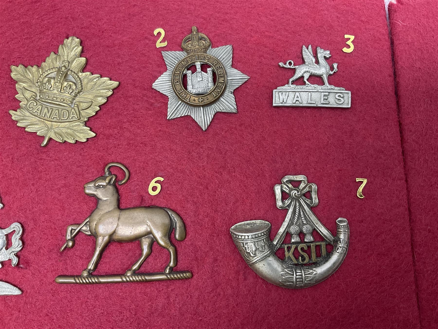 Forty glengarry and cap badges and shoulder titles including Gordon Highlanders, Canada and Canadian Field Artillery, New Zealand Field Artillery and Rifle Regiment, Shropshire Light Infantry, 14th/20th Kings Hussars, 17th Lancers, Northamptonshire Yeomanry, Royal Lincolnshire, Special Air Service, 19th Alexandra P.W.O. Hussars etc; mounted on two boards for display (2)