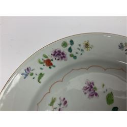 Three 18th century Chinese Famille Rose plates, the first example enamelled with blossoming peonies, rockwork and fence, the other two examples of similar design, decorated with blossoming peonies and sprigs within shaped inner borders, each approximately D23cm