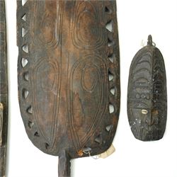 Papua New Guinea Middle Sepik carved sago plate with crocodile head handle L81cm, two Sepik masks/wall hangings inset with cowrie shells, larger 90cm and a small mask (4)