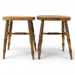 Pair of country elm stools, with oval dished seat raised on turned wooden supports, united by a H-stretcher