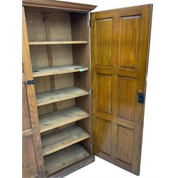 The North of England School Furnishing Company Limited Darlington - early 20th century oak school cupboard, projecting moulded cornice over two panelled doors, fitted with shelves, on chamfered plinth base 