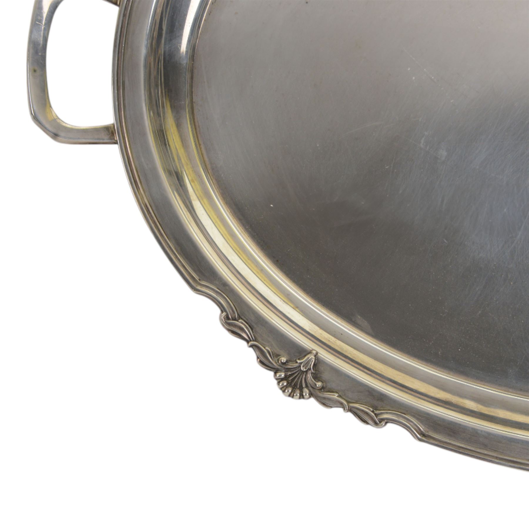 Modern silver twin handled serving tray, of oval form with stylised bud and tendril detail to rim, hallmarked Garrard & Co Ltd, Sheffield 1970, also impressed Garrard & Co Ltd 112 Regent Street beneath, including handles L64cm
