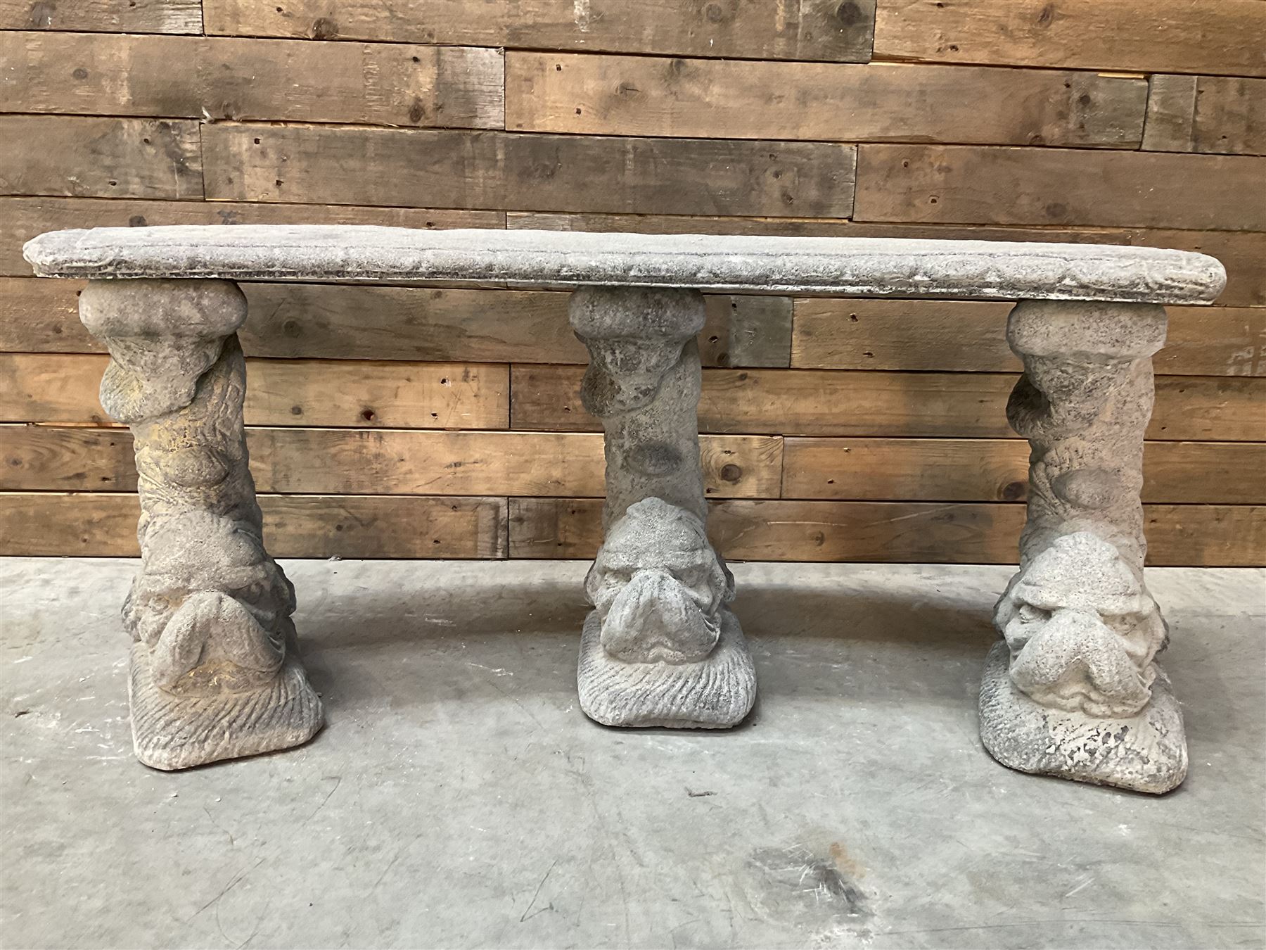 Cast stone four piece curved Dolphin bench, set with three dolphin pillars, curved rectangular slab top with detailed border