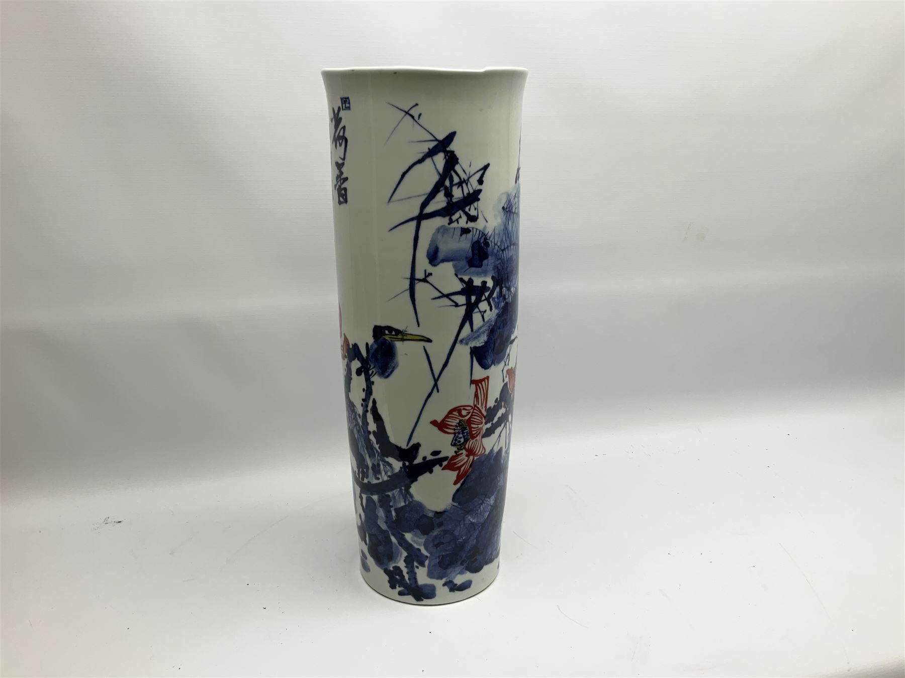 Chinese floor vase of cylindrical form decorated in blue, white and red wih birds perched upon blossoming branches, with flared rim, H62cm