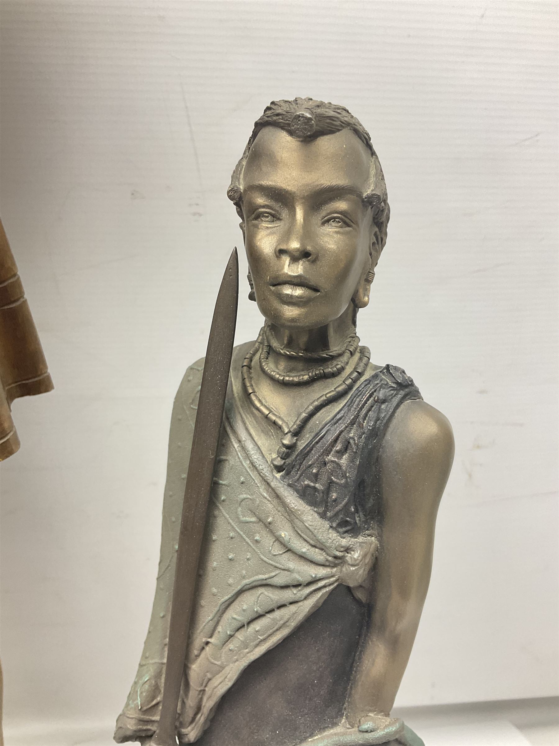 Spanish carved figure of Don Quixote, holding a book, base stamped 'Ouro, together with two spelter figures and one other