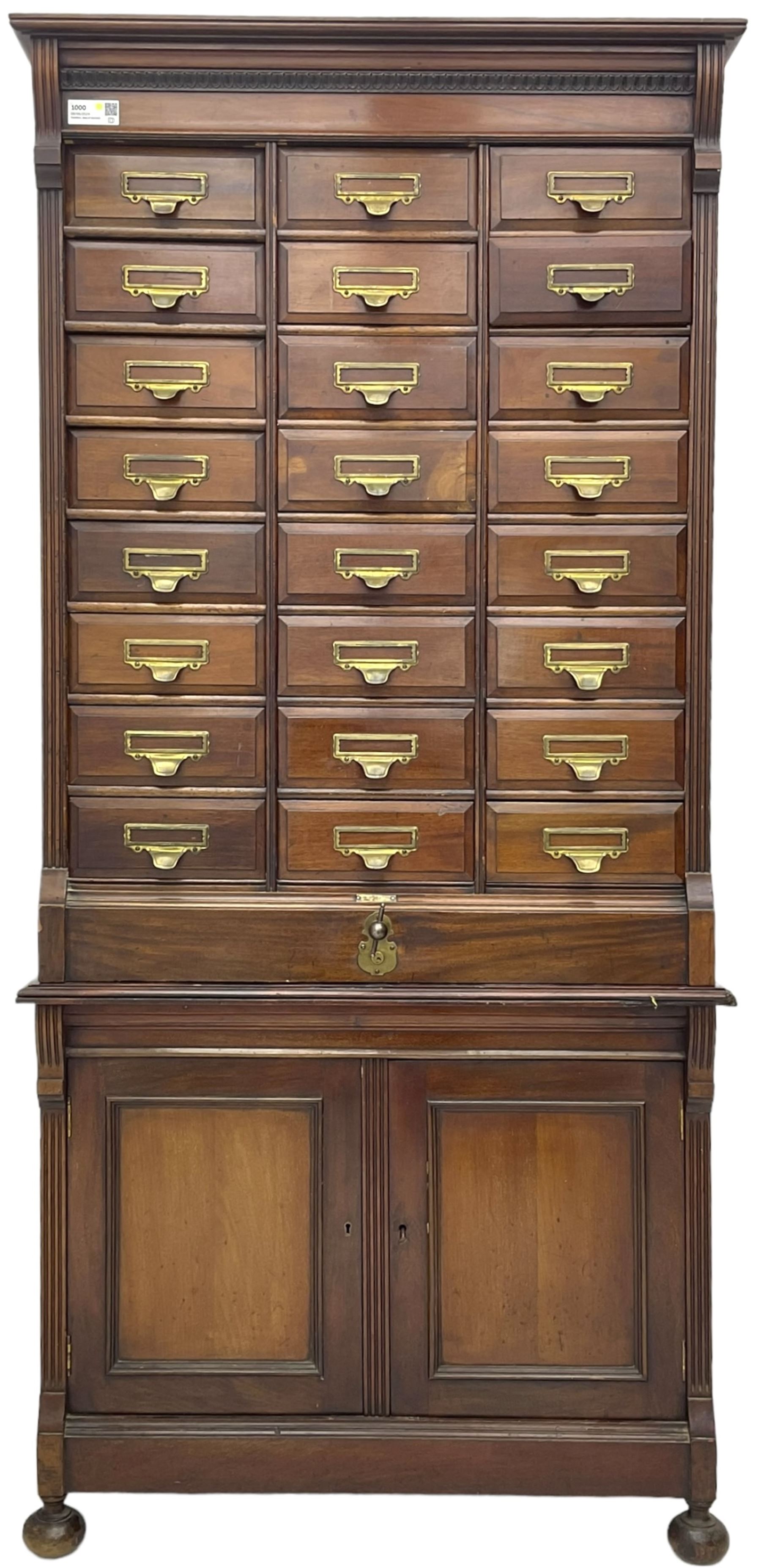 The Shannon Limited - late Victorian walnut filing cabinet, fitted with twenty-four small filing drawers, each with brass handle with label holder, fluted uprights, double cupboard below enclosed by two panelled doors, on turned feet, with brass plaque inscribed 'The Shannon, Limited, Ropemaker St. London, E.C.'