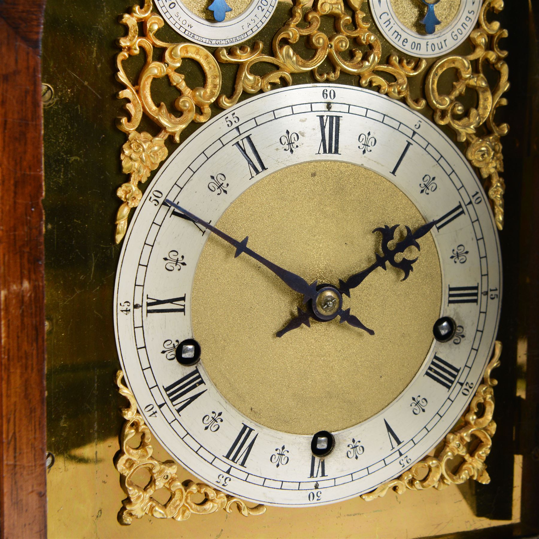 Winterhalder and Hoffmeier - German 8-day three train Edwardian oak cased mantle clock, with a break arch pediment, brass sound frets to the sides and conforming glazed door beneath, with flanking reeded pilasters on a stepped plinth raised on paw feet, sheet brass dial with fretted spandrels and matted dial centre, silvered chapter with Roman numerals, gothic steel hands and subsidiary dials for pendulum regulation and chime select, going barrel movement, chiming the quarters and striking the hours on nine coiled steel gongs. With pendulum and keys.