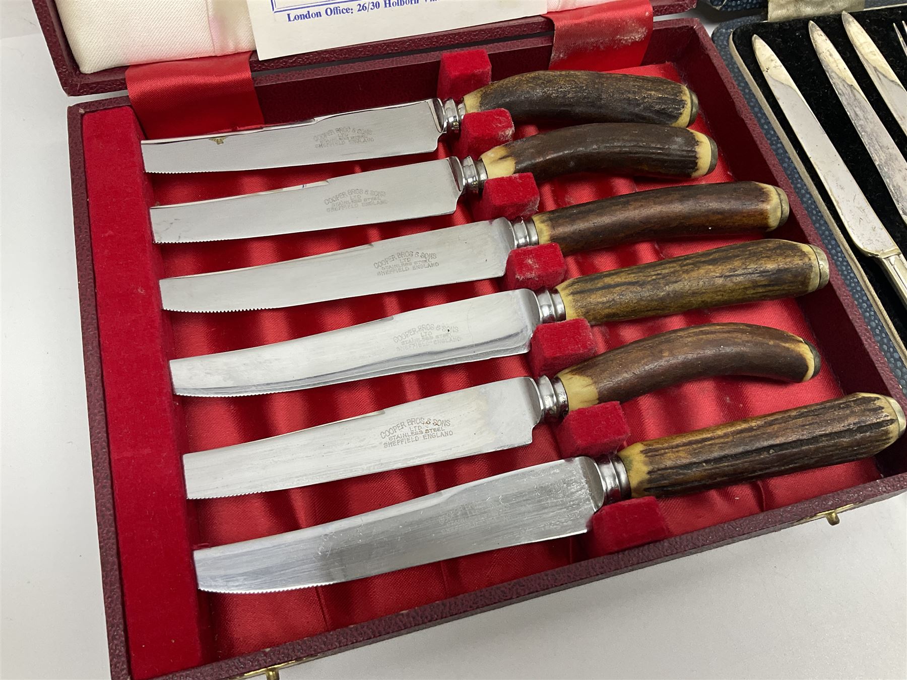 Set of six stag horn handled knives by Cooper Brothers and Sons, together with a set of silver plated dessert knives and forks for six place settings, both within fitted cases