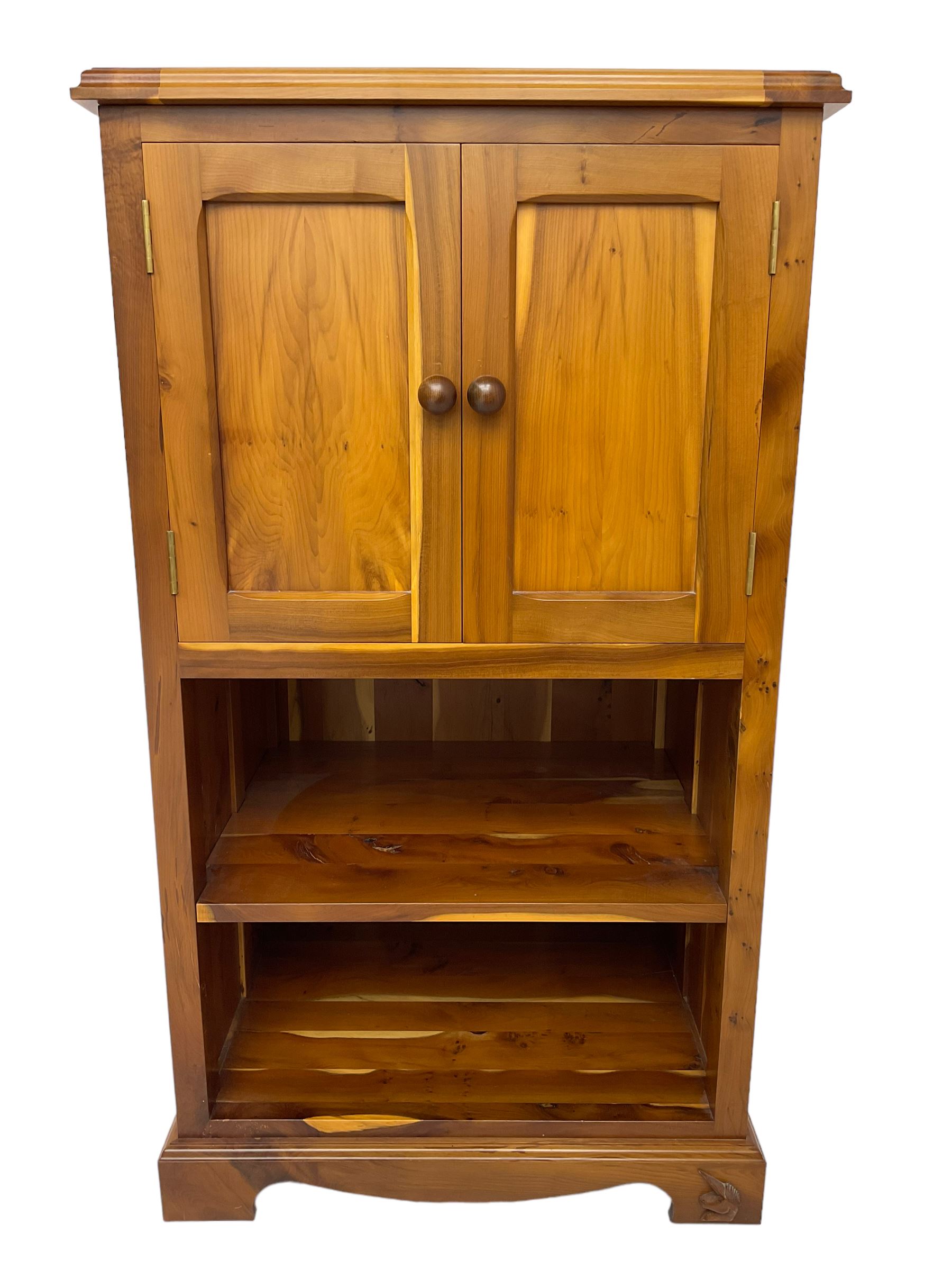 Unicornman - yew wood cabinet, moulded hinged lid over two panelled doors and shelves (W56cm, H99cm, D45cm); and four Unicorn man CD racks two in yew wood and two in oak (W20cm, H36cm, D20cm); all carved with unicorn signature and by Geoff Gell, Coxwold
