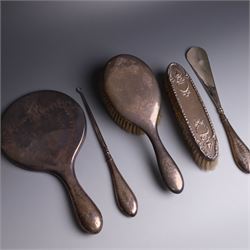 Early 20th Century silver mounted dressing table set, comprising hand mirror, shoe horn and a button hook, each with engraved floral decoration, together with a silver mounted hairbrush and clothes brush, all hallmarked
