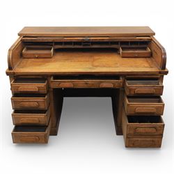 Globe Wernicke - Oak roll top desk, fitted with nine drawers, oak tambour roll top revealing a fitted interior, with single frieze drawer, flanked by four drawers to each pedestal, on a plinth base
