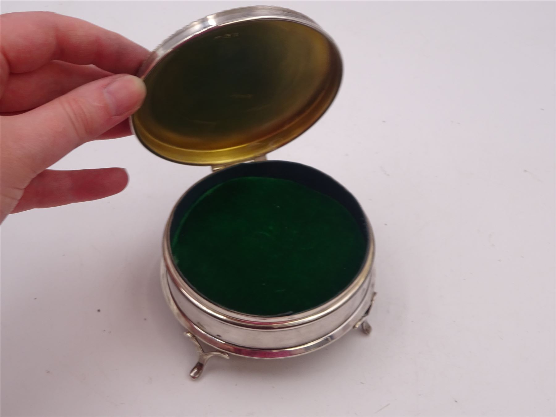 1920s silver mounted jewellery box, of circular form, with bead and dart rim to hinged cover, opening to reveal gilt velvet lined interior, upon four pad feet, hallmarked Charles Edwards, London 1920, H4.5cm
