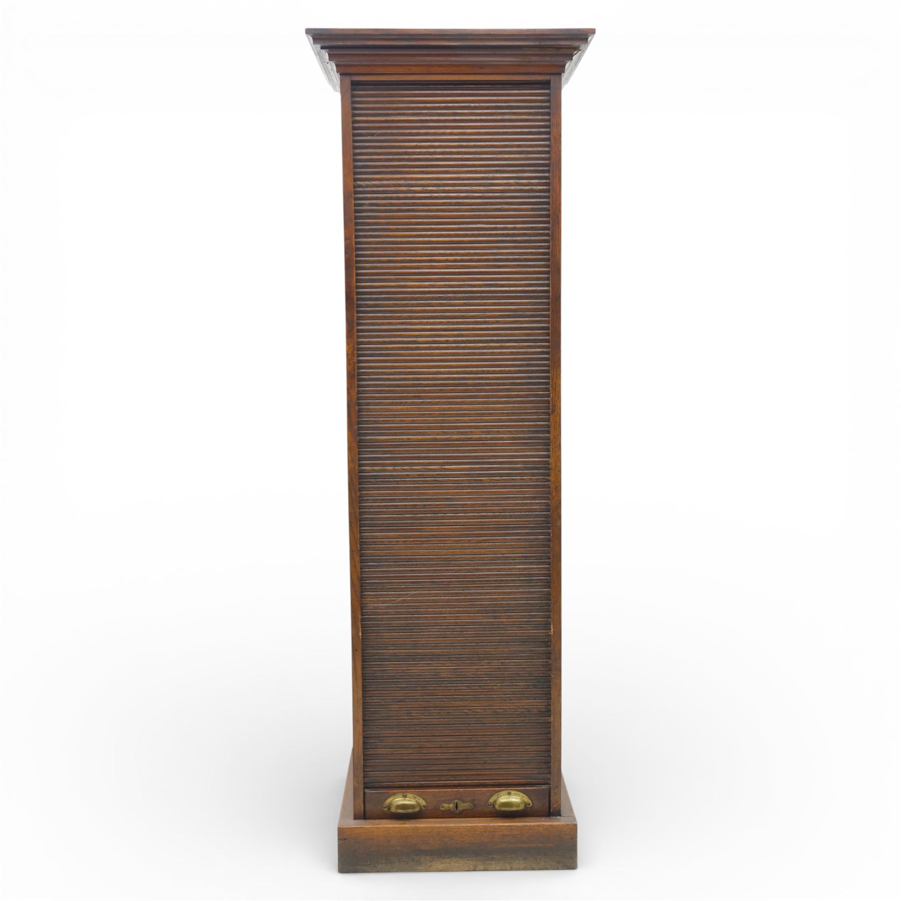 Edwardian oak pedestal office cabinet, moulded rectangular top over tambour shutter enclosing fitted interior, with fifteen graduated drawers each with recessed brass cup handle and label holders, panelled sides, on plinth base