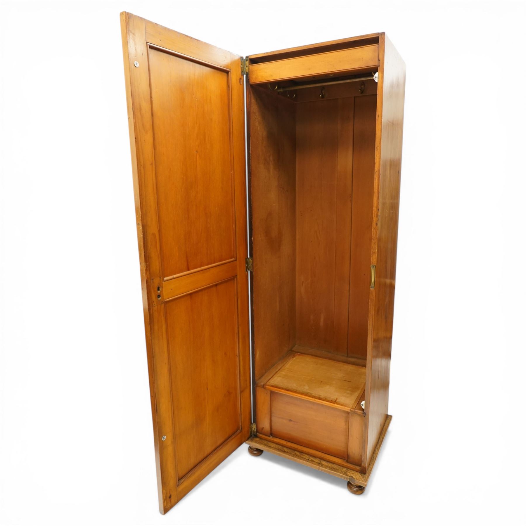 Late 19th century Arts & Crafts stained pine single hall wardrobe, single panelled door with brass fittings enclosing sliding tray to top with hanging rail and hooks, hinged box seat to base, on compressed bun feet