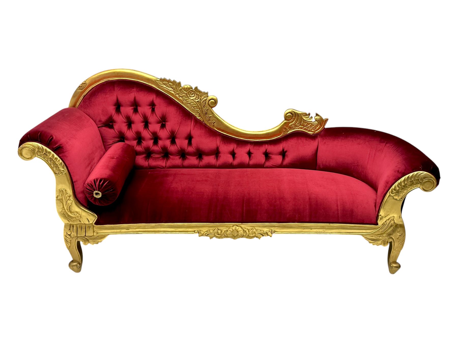 Victorian design giltwood chaise longue, the curved backrest and seat upholstered in deep red velvet with tufted detailing, the frame carved with floral motifs and scrolling acanthus leaves, raised on shaped cabriole supports
