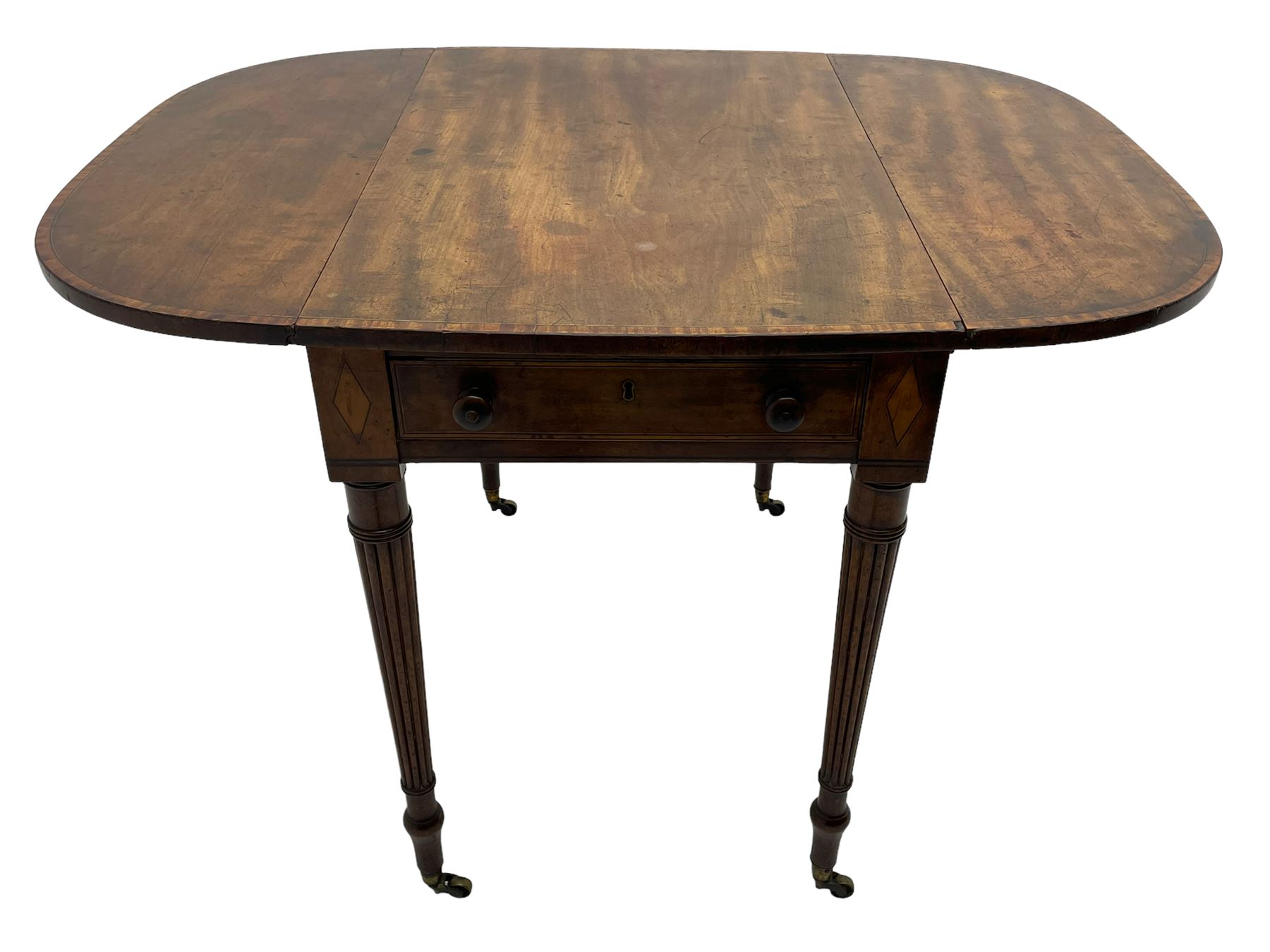 George III mahogany Pembroke table, drop-leaf oval top with satinwood band, fitted with single end drawer, inlaid with satinwood lozenge motifs, on turned and reeded supports with brass cups and castors
