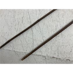 Native long-shafted spear, the large iron head with central medial ridge and decorative neck, on plain circular haft L260cm; and another similar Native long-shafted spear with cane haft L249cm (2)