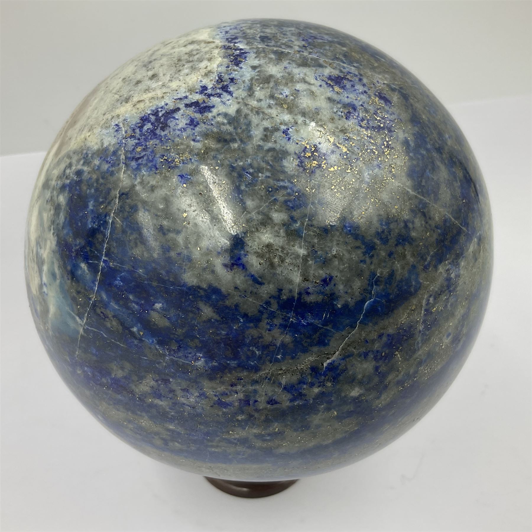 Lapis lazuli sphere upon a carved wooden base 