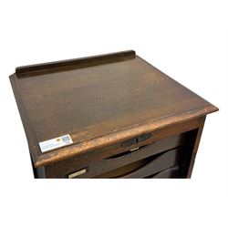Two early 20th century mahogany tambour cabinets, each with retractable roll-top front revealing fitted interior with concave-front filing drawers and brass fittings