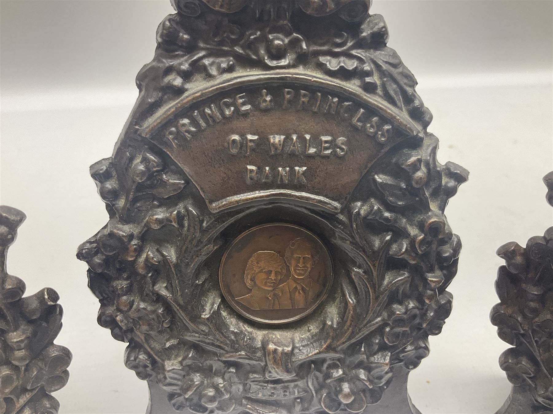 Two early 20th century cast-iron money banks - 'Our Kitchener Bank' c1914 H17cm and 'Our Empire Bank' c1911 depicting George V and Queen Mary H17cm; both by Sydenham & McCoustra; and another similar for The Prince & Princess of Wales 1981 by Robert Brown (3)