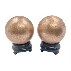 Pair of copper spheres, upon carved wood