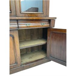 Victorian mahogany bookcase on cupboard, projecting cornice over two glazed doors and carved corbels, fitted with two drawers and double cupboard, plinth base