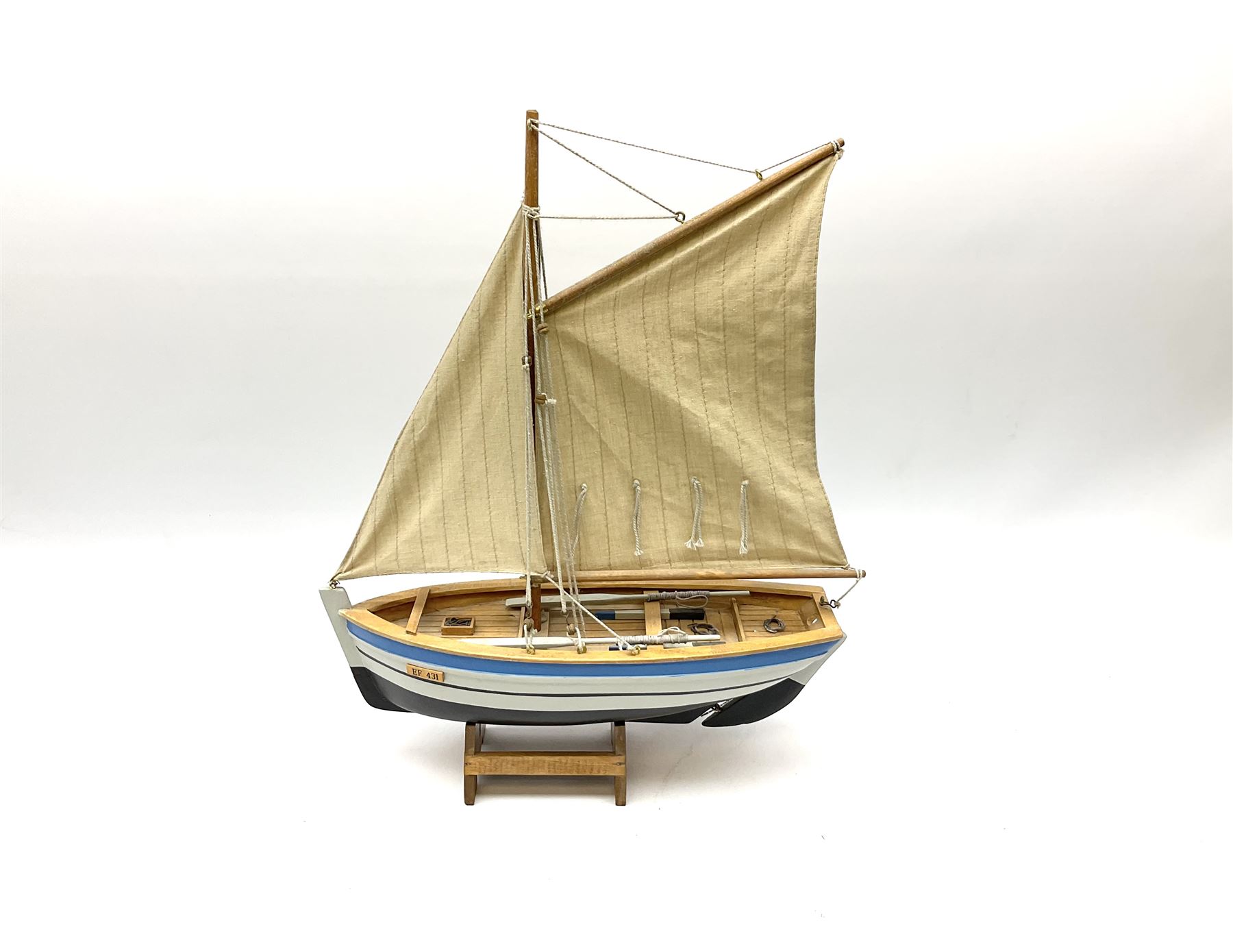 Wooden model of RMS Titanic, on a fixed black stand bearing plaque inscribed 'Titanic 1912', L54cm, H22cm, together with model of a sloop, gaff rigged on stand bearing plaque inscribed 'Sloop' L32cm, H42cm; and model of a fishing trawler on a stand bearing plaque inscribed 'Chalutier' L35cm, H28cm (3)