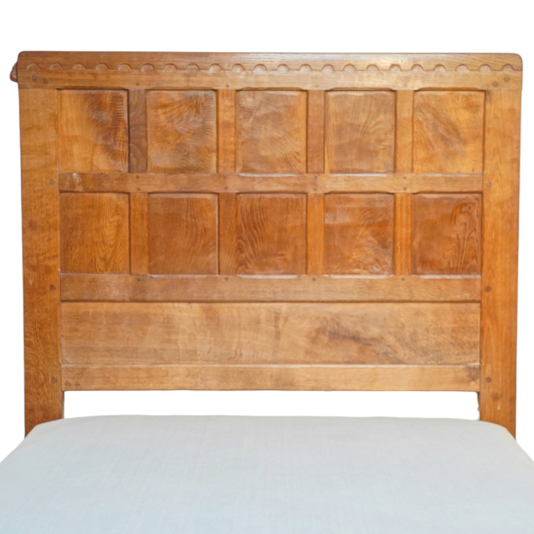 Mouseman - pair of 1930's adzed and panelled oak single beds, the head and foot-boards with arcade-carved cresting rails above adzed panels, with Vibase mattress supports, carved with mouse signature, by the workshop of Robert Thompson of Kilburn