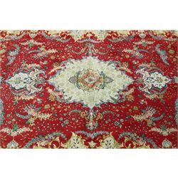Persian silk inlaid crimson ground Kashan rug, the central shaped field with a floral pole medallion surrounded by trailing floral motifs and festoons of flowerheads, the wide cyan guard line with repeating palmettes and scrolling floral vines