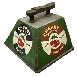 Cherry Blossom Shoe Polish shoe shine box, of sloping form, with three pictorial enamel panels advertising dark tan, black and light tan polishes, the reverse with a hinged compartment, the top mounted with a handle and foot rest in the form of a shoe sole, H29cm W42cm D33cm