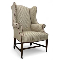 Edwardian mahogany wing back armchair upholstered in a geometric brocade type fabric, on f...