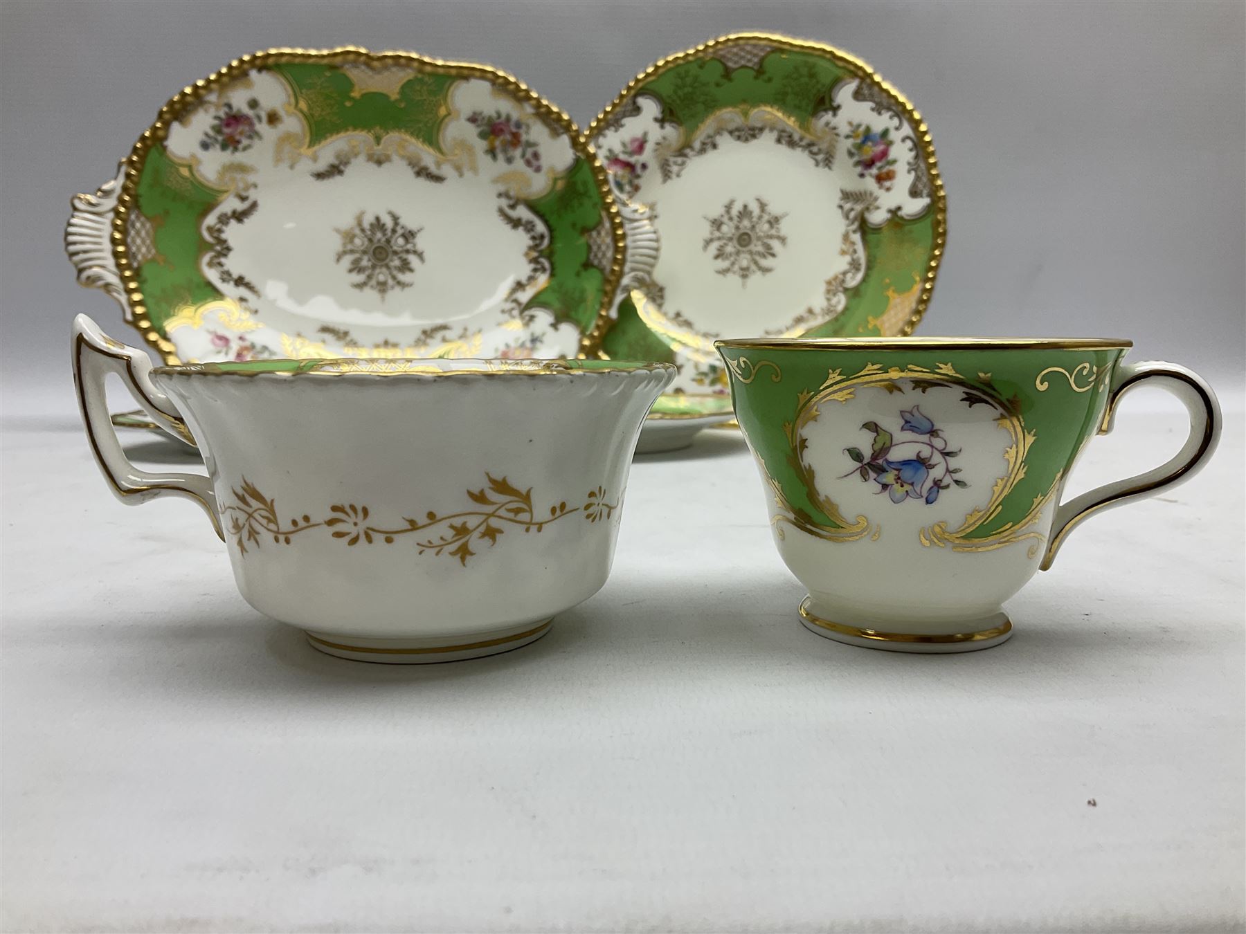 Coalport green batwing pattern tea wares, decorated with finely enamelled floral sprays within gilt reserves, comprising teacup trio, twin handled cake plate and side plate, pattern no Y2665, together with a Coalport for Harrods cup and saucer similarly decorated, the saucer with stamped mark beneath 'Manufactured for Harrods Ltd, Brompton Rd London', all with green Coalport AD 1750 marks beneath, largest W31cm (7)