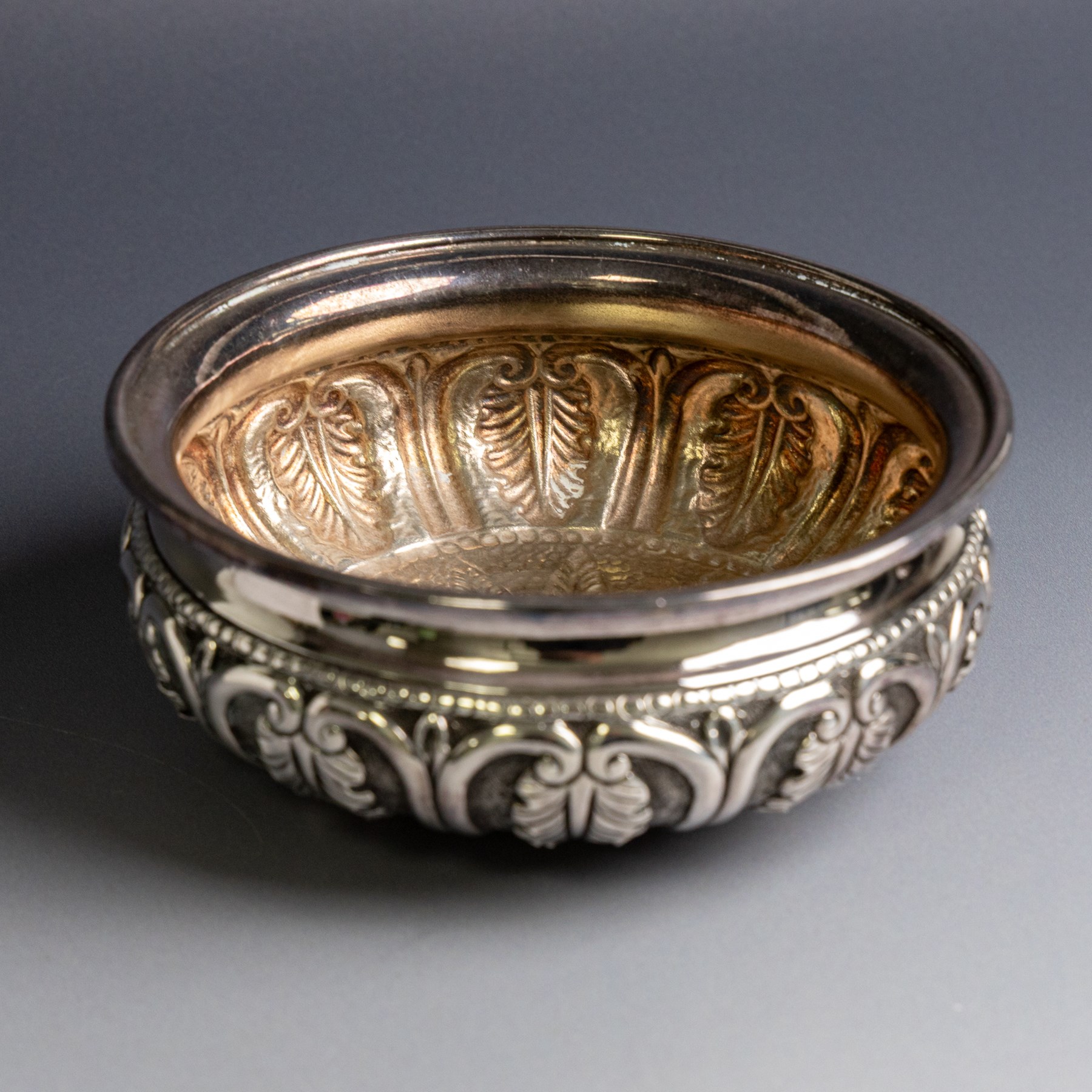Indian silver bowl, of circular form with embossed acanthus leaf decoration, upon three bun feet, D5.5cm, H13cm