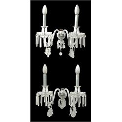 Pair of cut glass two branch wall sconce candelabras, each with S scroll extending branches with shaped and bevelled circular drip trays, hung with pendant drops