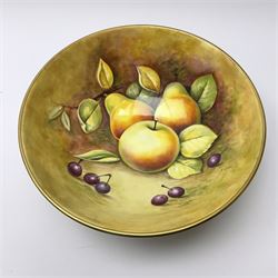 A Coalport bowl hand painted to the interior and exterior with fruit still life upon a mossy ground, signed N Lear, upon three scrolling gilt feet, D26.5cm. 