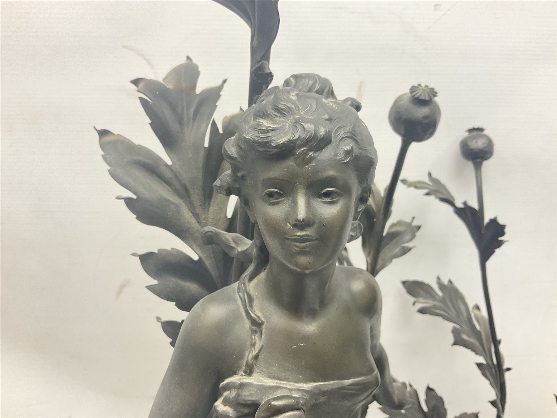Pair of Art Nouveau style spelter figural table lamps, each mounted on rouge marble effect circular bases, with toleware flower heads and leafy decoration surrounding a female figure, H90cm