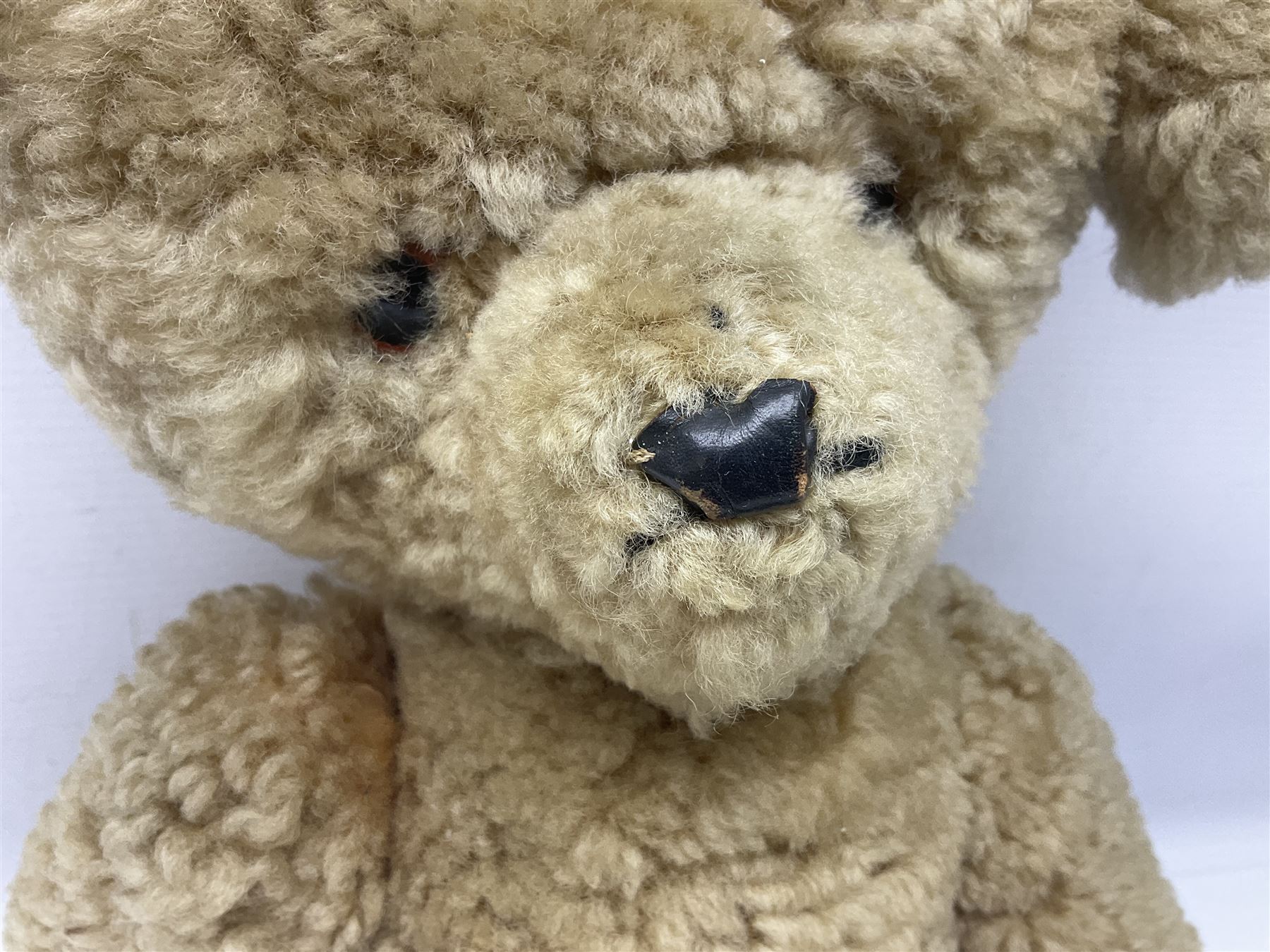 1950s sheepskin plush covered teddy bear with musical movement, the revolving head with applied eyes, leather nose and stitched mouth, jointed limbs with leather pads H50cm