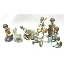  A group of Lladro and Nao figurines, comprising a trio modelled as boys playing instruments, boy with dog, boy with football, girl with puppy and kitten and a goose, (two a/f), all with printed mark beneath.   