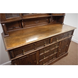  Early 20th century oak raised mirror back sideboard, projecting cornice, two glazed cupboards flanking a bevel edged mirror, five drawers, two cupboards, W170cm, H206cm, D60cm  