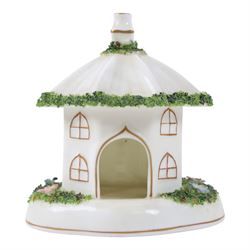 Collection of Coalport items, comprising floral mantel clock, houses including 'Park Lodge' 'The Umbrella House' 'Keepers Cottage', Coalbrookdale floral jar, and others; Kingmaker mouse ornament; Egyptian-style granite Bastet cat ornament, in one box