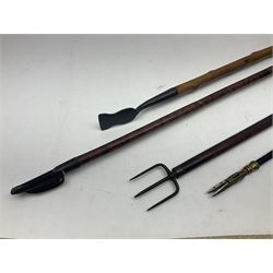 Two late 19th century fruit picker canes, the first example a French ebonised bamboo cane, with pair of fruit scissors to base, the handle stamped Cueille Fruit, the second example with grabbing action, the cap stamped A C Harris, Leicester, together with two other 19th century canes, one with fork and the other with hoe