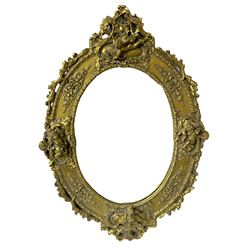 Composite ornate oval gilded wall mirror, decorated with putti and a foliate border, with oval bevelled mirror plate, H53cm