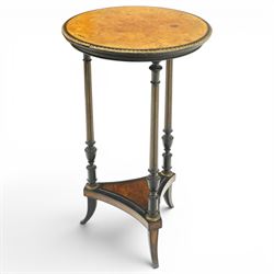 Late Victorian Aesthetic Movement ebonised and figured walnut occasional table, the circular burr top with boxwood strung and ebonised edge, surrounded by gilt metal egg-and-dart moulding, raised on three turned and fluted pedestals with parcel-gilt decoration, united by a triform undertier raised on splayed feet