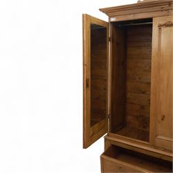 Late 19th century pine wardrobe, with stepped cornice over triple panelled doors, applied foliate carvings to outer panels, raised over a separate pine plinth drawer with moulded facia and twin glass pulls
